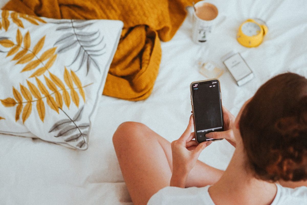 woman on bed looking at phone